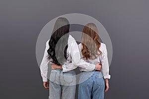 Back view of two unrecognizable women hugging each other. Friendship, family love concept