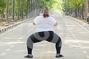 Back view of unidentified fat woman squatting