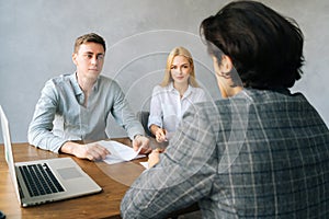 Back view of unrecognizable male applicant introducing during job interview, talking about working experience