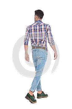 Back view of walking casual man looking to side