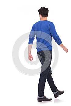 Back view of a walking casual man looking to a side