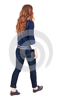 Back view of walking woman .