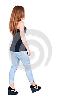 Back view of walking woman.