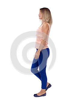 Back view of walking woman. beautiful blonde girl in motion. b