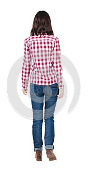 Back view of walking woman in checkered shirt.