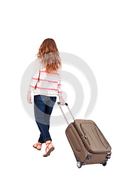 Back view of walking woman with suitcase.