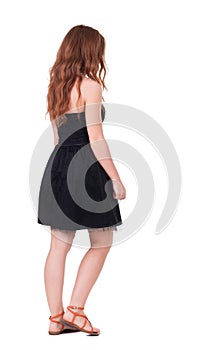 Back view of walking young beautiful redhead woman