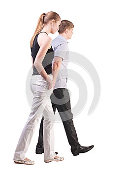 Back view of walking young couple