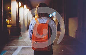 Back view woman with backpack on background bokeh light in night atmospheric city, blogger hipster planing holiday travel, mockup