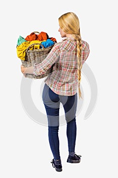 Back view of woman with basket dirty laundry. girl is engaged in washing.