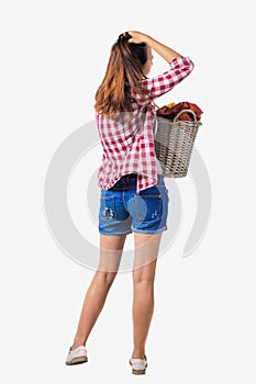 Back view of woman with basket dirty laundry. girl is engaged in washing.