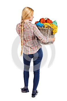 Back view of woman with basket dirty laundry. girl is engaged in washing.