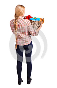 Back view of woman with basket dirty laundry. girl is engaged in washing.