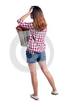 Back view of woman with basket of dirty laundry. girl is engaged in washing.