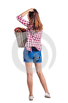 Back view of woman with basket dirty laundry. girl is engaged in washing.