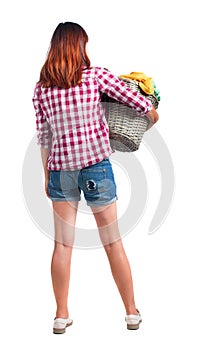 Back view of woman with basket dirty laundry. girl is engaged in washing.