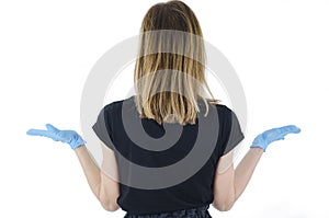 Back view of woman confusing. Young shocked woman with hand up. Rear view of young woman with blue gloves with hand up.