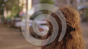 Back view of a woman with curly ginger hair