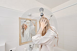 Back view of a woman dries her hair with a hair dryer