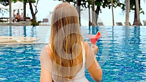 Back view of woman enjoy summer vacation in luxury beach resort