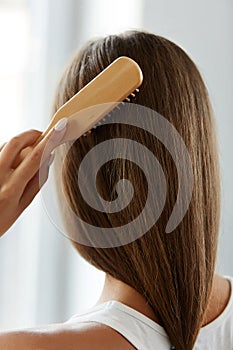 Back View Of Woman With Healthy Long Hair Brushing It With Brush