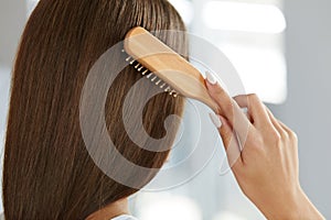 Back View Of Woman With Healthy Long Hair Brushing It With Brush