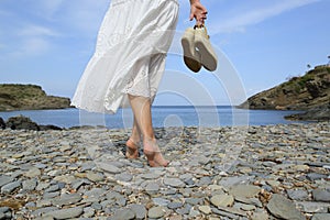 Back view of woman legs walking on the beach