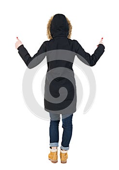 Back view of woman in parka thumbs up.