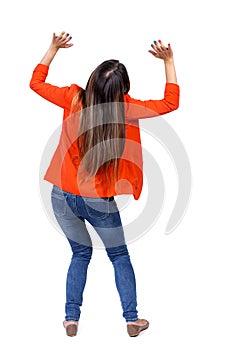 Back view of woman protects hands from what is falling from abo