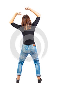 Back view of woman protects hands from what is falling from abo