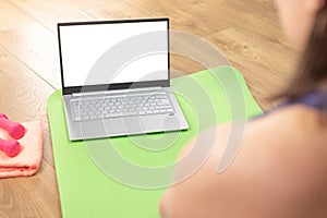 Back view of woman relax at home enjoy yoga online training practice course on mockup laptop, woman watch fitness sports workout