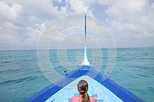 Back view of a woman sailing in a boat looking out to sea