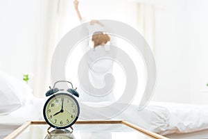 Back view of woman stretching in morning after waking up on bed photo