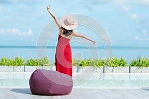 Back view of woman stretching and  relaxing by swimming pool