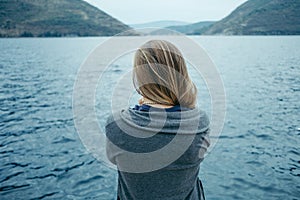 Back view of woman thinking alone and watching the sea with the