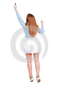 back view of writing beautiful redhead woman. Young girl in dres