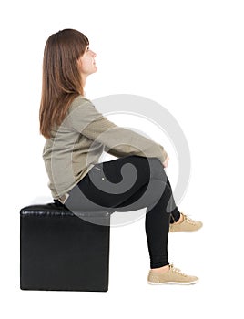 Back view of young beautiful woman sitting.