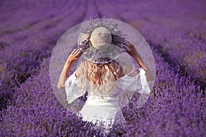 Back view of Young blond woman in lavender field. Happy carefree