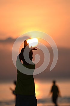 Back view of a young boy silhouette standing during sunset