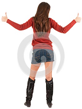 Back view of young brunette woman in jeans and sweater going