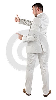 Back view of young business man in white suit going thumb up