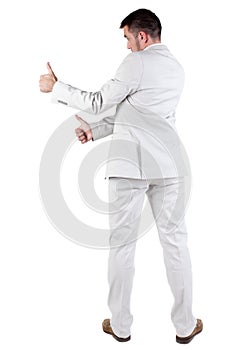 Back view of young business man in white suit going thumb up