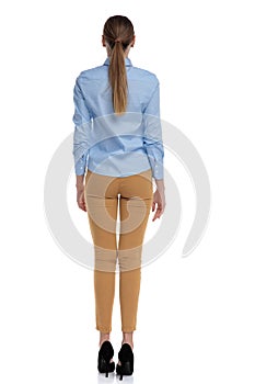 Back view of young businesswoman wearing blue shirt