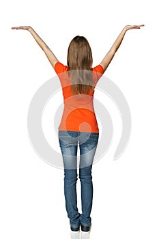 Back view of young casual female in full length holding blank copy space