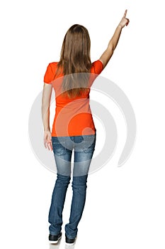 Back view of young casual female in full length pointing at blank copy space