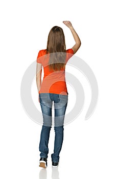 Back view of young casual female in full length writing on the blank copy space