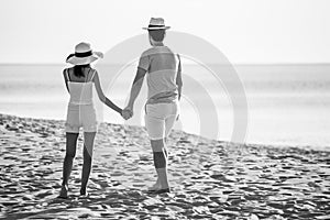 back view of Young couple in love  looking the future   and holding hand together at sea beach  .happy smiling young wedding with