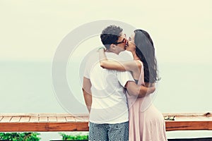 Back view of young couple standing at the top and watching seaview