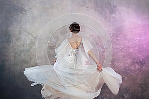 Back view of a young elegant brunette bride with a stylish hairstyle.