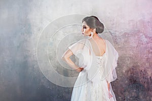 Back view of a young elegant brunette bride with a stylish hairstyle.